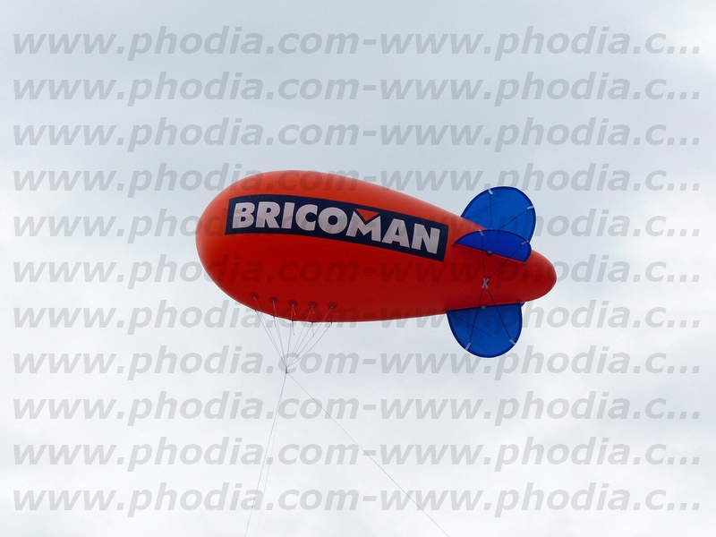 Dirigeable rouge ailerons bleu pour magasin Bricoman