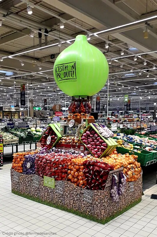 Une PLV gonflable en forme d'oignon géant sur un étalage de supermarché